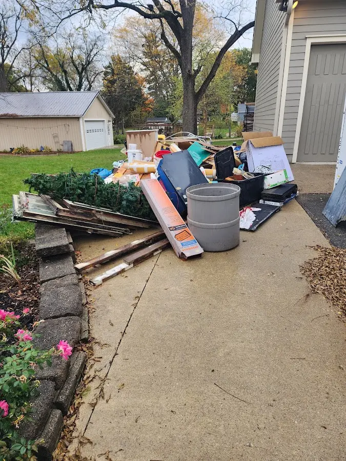 Dumpster being loaded with debris for Estate Cleanout Dumpster Rental in White Lake